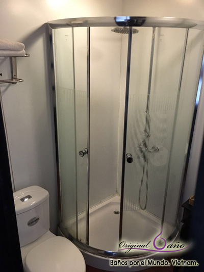 Baño pequeño de crucero, zona de plato de ducha con barra de ducha.